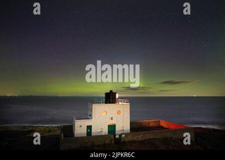Les aurores boréales, mieux connues sous le nom de lumières nordiques, apparaissent tôt le matin au-dessus du phare de Bamburgh, dans le Northumberland. Au Royaume-Uni, le soleil et les averses seront visibles après un mélange de chaleur intense et de pluie torrentielle au cours des dernières semaines. Date de la photo: Vendredi 19 août 2022. Banque D'Images
