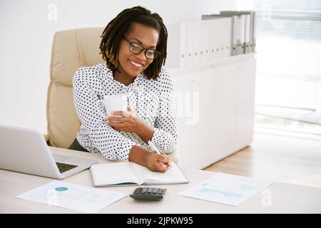 Une femme d'affaires afro-américaine joyeuse qui travaille au bureau Banque D'Images
