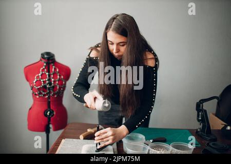 Tanner femme faisant des marchandises de ceinture de harnais en cuir sur l'atelier.Processus de travail de l'artisan du cuir. Banque D'Images