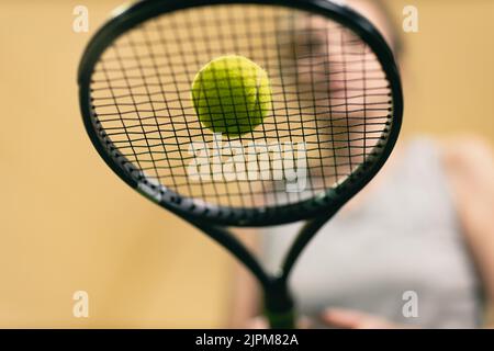 Une joueuse de tennis tient la raquette et le ballon sur le court.Vue de dessous Banque D'Images