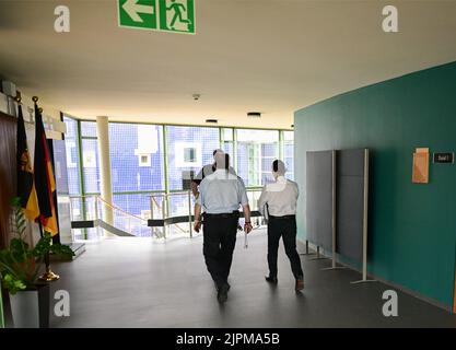 Pforzheim, Allemagne. 19th août 2022. Le défendeur r) dans un procès pour le vol d'environ 38 kilogrammes de copeaux d'or est conduit dans une salle d'audience par le personnel du tribunal. L'homme aurait pillé les copeaux d'or d'une entreprise de bijoux de Pforzheim pendant une longue période. Le procès a lieu au bureau de la Cour régionale de Karlsruhe à Pforzheim. Credit: Bernd Weißbrod/dpa/Alay Live News Banque D'Images