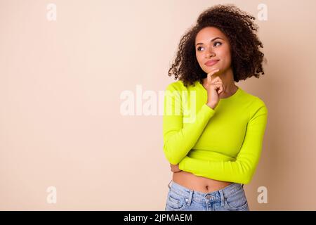 Photo portrait de jeune belle dame cheveux bouclés rêve week-end parfait shopping porter élégant costume jaune isolé sur fond beige couleur Banque D'Images