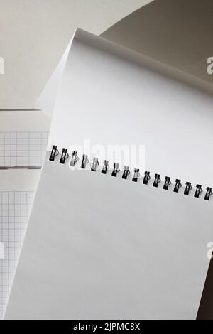 Modèle d'espace de copie métier. Mise à plat d'un espace de travail minimaliste avec bloc-notes spirale vierge sur fond blanc. Banque D'Images
