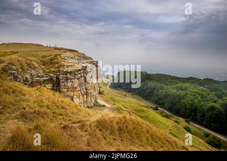 Castle Rock sur la Cotswold Way à Cleeve Hill surplombant un spa couvert de brume Cheltenham, Gloucestershire, Angleterre Banque D'Images