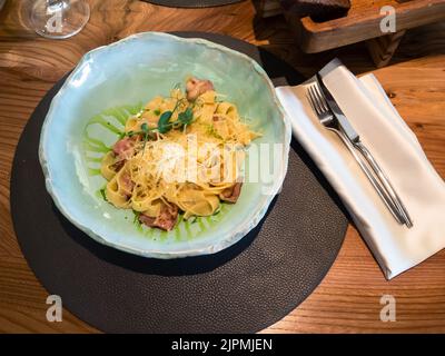 Vue ci-dessus de la portion Fettuccine Carbonara dans un bol bleu dans le restaurant local Banque D'Images