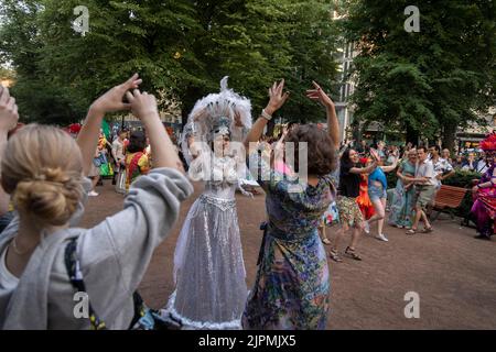 Helsinki, Finlande. 18th août 2022. Des gens dansent avec des danseurs de samba pendant la nuit des arts à l'Esplanade Park à Helsinki, Finlande, le 18 août 2022. La nuit des arts, aujourd'hui une tradition d'Helsinki, a été célébrée jeudi, avec diverses manifestations artistiques organisées dans différents lieux. De nombreux musées offrent une entrée gratuite et certaines galeries et musées prolongent leurs heures d'ouverture pendant l'événement. Credit: Matti Matikainen/Xinhua/Alamy Live News Banque D'Images