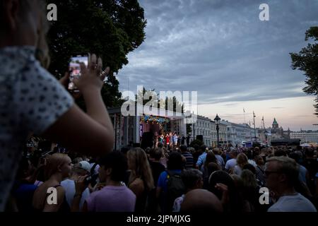 Helsinki, Finlande. 18th août 2022. Les gens regardent une représentation en plein air pendant la nuit des arts à l'Esplanade Park à Helsinki, Finlande, le 18 août 2022. La nuit des arts, aujourd'hui une tradition d'Helsinki, a été célébrée jeudi, avec diverses manifestations artistiques organisées dans différents lieux. De nombreux musées offrent une entrée gratuite et certaines galeries et musées prolongent leurs heures d'ouverture pendant l'événement. Credit: Matti Matikainen/Xinhua/Alamy Live News Banque D'Images