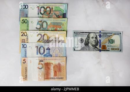 Billets en valeurs unitaires de 100,50,20,10.5 roubles biélorusses et de 100 dollars sur fond gris Banque D'Images