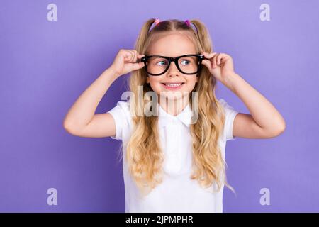 Photo de charmante petite fille queues bras toucher oculaire oculiste à carreaux habillé élégant chemisier blanc isolé sur fond violet couleur Banque D'Images