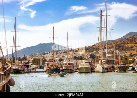 Vue sur de nombreux yachts et bateaux amarrés au port de Bodrum par une belle journée d'été. Ciel nuageux et montagnes à l'arrière-plan. Banque D'Images