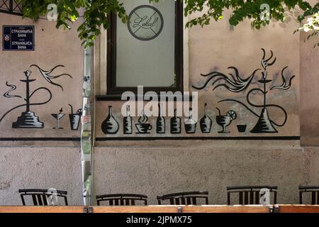 Belgrade-Serbie - 15 juin 2022: Détail de la façade mur de bar de shisha avec graffiti dessin de bouteilles, boissons, café, cocktails, verres et narguilé Banque D'Images