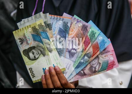 Bandung, Indonésie. 19th août 2022. Une femme affiche de nouveaux billets indonésiens à Bandung. Le gouvernement indonésien et Bank Indonesia ont lancé sept nouveaux billets pour commémorer le 77th anniversaire de l'indépendance de l'Indonésie. (Photo par Algi Febri Sugita/SOPA Images/Sipa USA) crédit: SIPA USA/Alay Live News Banque D'Images