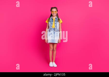 Photo du corps complet de funky école blonde fille stand vêtements lunettes t-shirt gilet jupe chaussures isolées sur fond fuchsia couleur Banque D'Images