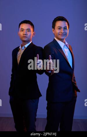 Portrait de deux entrepreneurs heureux montrant le pouce vers le haut Banque D'Images