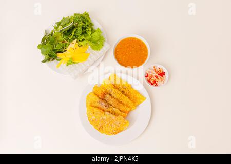 Banh xeo, crêpes vietnamiennes ou crêpes avec porc, crevettes, oignons, pousses de béasn à l'intérieur et sauce de poisson, nourriture vietnamienne isolée sur fond blanc; Banque D'Images