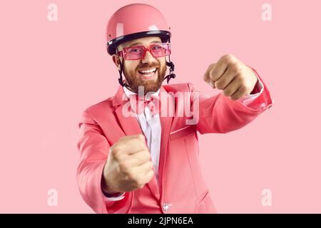 Studio portrait de drôle heureux homme rire tout en prétendant conduire la voiture invisible Banque D'Images