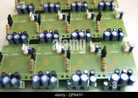 Un homme collecte une carte de circuit imprimé. Le travailleur souéquipe les composants de la radio et assemble le dispositif fini. Montage et commande manuels Banque D'Images