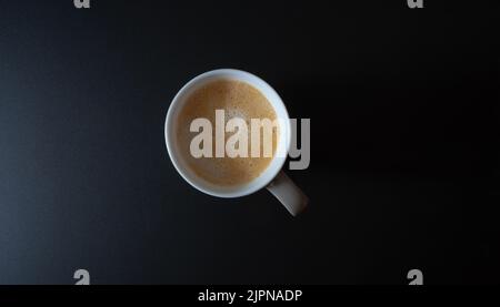 vue de dessus en bas d'une tasse de café ou d'un latte sur une table sombre Banque D'Images