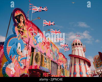 Un parc d'attractions/plage de loisirs haut en couleur en bord de mer avec un abri de squelettes et des drapeaux britanniques volant Hunstanton Norfolk Angleterre Royaume-Uni Banque D'Images