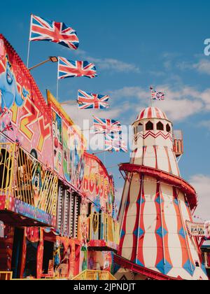 Un parc d'attractions/plage de loisirs haut en couleur en bord de mer avec un abri de squelettes et des drapeaux britanniques volant Hunstanton Norfolk Angleterre Royaume-Uni Banque D'Images