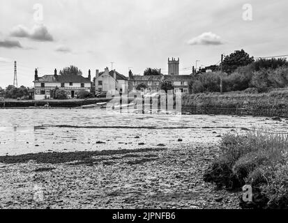 Image saisissante, noire et blanche de Cottages au quai, Bere Ferrers sur les rives de la rivière Tavy. La marée est basse avec des modèles dans le lit de la rivière. Banque D'Images