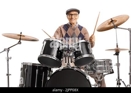 Homme âgé jouant sur un kit de batterie isolé sur fond blanc Banque D'Images