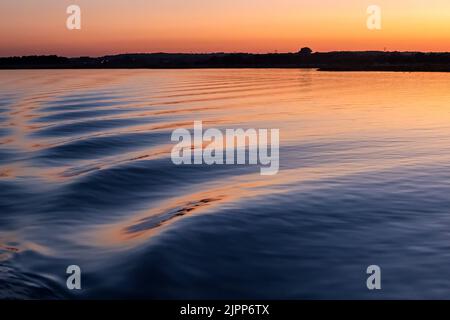 Des vagues de proue au coucher du soleil, Poole Harbour, en été Banque D'Images