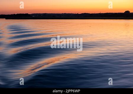 Des vagues de proue au coucher du soleil, Poole Harbour, en été Banque D'Images