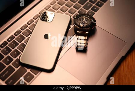 Tbilissi, Géorgie - 26 juillet 2022: Montre moderne de pomme de smartphone sur clavier d'ordinateur portable. Banque D'Images