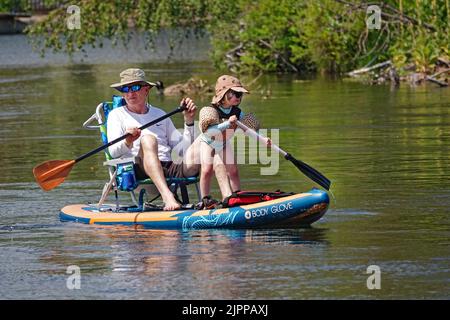 Grand-père et petite-fille flottent sur la rivière Deschutes à Bend, Oregon, sur un paddleboard essayant d'échapper à la vague de chaleur de 100 degrés F qui balaie le Nord-Ouest du Pacifique. Banque D'Images