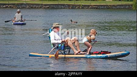 Grand-père et petite-fille flottent sur la rivière Deschutes à Bend, Oregon, sur un paddleboard essayant d'échapper à la vague de chaleur de 100 degrés F qui balaie le Nord-Ouest du Pacifique. Banque D'Images