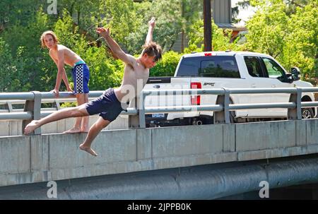 Les jeunes garçons se rafraîchissez en plongeant dans la rivière Deschutes à Bend, Oregon, en essayant d'échapper à la vague de chaleur de 100 degrés F qui balaie le Nord-Ouest du Pacifique. Banque D'Images