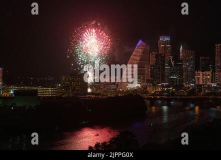 Les plaisanciers ponctuent la surface du lac Lady Bird pour le traditionnel feu d'artifice du 4 juillet au centre-ville d'Austin. Le nouveau bâtiment Google au centre reflète la lumière de l'énorme feu d'artifice. Cette photo est prise de Rainey Street, en regardant vers l'ouest sur le lac. ©Bob Daemmrich Banque D'Images