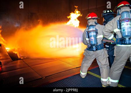 Les marins affectés à l'unité de pré-mise en service (UCP) John F. Kennedy (CVN 79) combattent un incendie simulé pendant la formation à la lutte contre les incendies à l'école de lutte contre les incendies de Farrier. L'école organise des cours de formation sur la lutte contre les incendies et le contrôle des dommages, accueillant des centaines d'élèves chaque semaine. John F. Kennedy est le deuxième porte-avions de classe Ford et est en construction au chantier naval Huntington Ingalls Industries Newport News. Banque D'Images