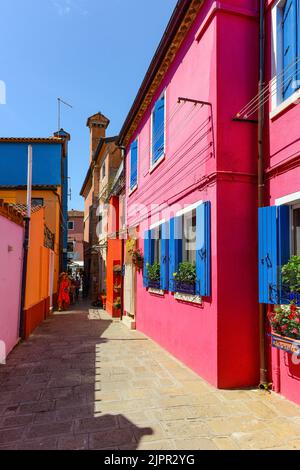 ÎLE DE BURANO, VENISE, ITALIE - 4 JUILLET 2022 : personnes marchant dans le village. L'île, près de Venise, est célèbre pour ses maisons colorées. Immo Banque D'Images