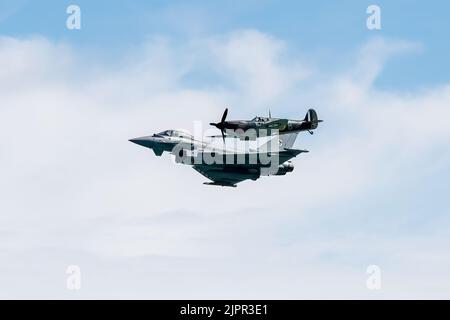 Eastbourne, East Sussex, Royaume-Uni. Présentant le typhon de la RAF en tandem avec un à la bataille de Brittain Spitfire au spectacle aérien annuel d'Eastbourne, vu depuis la plage d'Eastboune. 18th août 2022. Credit David Smith/Alamy Live News Banque D'Images