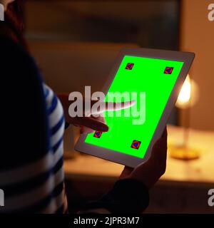 Parcourir ses sources en ligne d'informations commerciales précieuses. Gros plan d'une femme d'affaires non identifiable travaillant tard sur une tablette numérique avec Banque D'Images