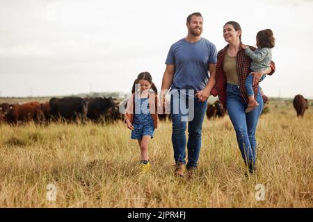 Famille d'agriculteurs, ferme de vaches et mère, père et enfants en lien avec l'environnement ou la campagne développement durable domaine agricole. Des gens et des enfants heureux Banque D'Images