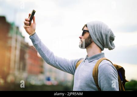 Wheres le réseau quand vous en avez besoin. Un jeune homme utilisant son téléphone mobile pendant que vous êtes en ville. Banque D'Images