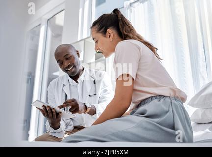 Rendez-vous avec un médecin ou un professionnel de la santé qui consulte un patient et lui montre ses résultats médicaux en ligne sur un comprimé. Un professionnel de la santé ou un médecin traitant Banque D'Images