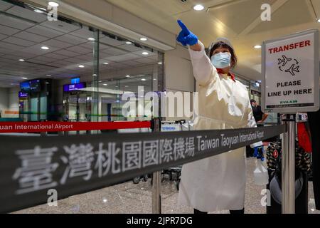Taoyuan, Taoyuan, Taïwan. 19th août 2022. Le personnel de l'aéroport de l'EPI, qui est muni d'un pulvérisateur d'alcool, réagit dans la zone restreinte de l'aéroport international de Taoyuan de Taïwan, car l'île reste soumise à des mesures de quarantaine et à des restrictions strictes de la COVID-19. Alors que de nombreuses régions du monde ont rouvert les frontières pour un voyage international gratuit, des endroits en Asie comme Taiwan, Hong Kong et la Chine continentale, qui sont autonomes, exigent toujours que les passagers subissent une quarantaine et imposent des mesures obligatoires de port de masque. (Image de crédit : © Daniel Cing Shou-Yi/ZUMA Press Wire) Banque D'Images