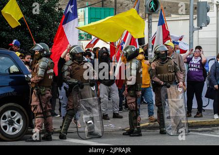 Valparaiso, Chili. 19th août 2022. Les policiers sont sous garde tandis que les manifestants brandissent les drapeaux chiliens et brandissent des slogans lors d'une protestation contre une nouvelle constitution. Des manifestants s'empaissent dans les rues de Valparaiso pour rejeter une nouvelle constitution, certains contre-manifestants soutenant la nouvelle constitution de Valparaiso. Crédit : SOPA Images Limited/Alamy Live News Banque D'Images