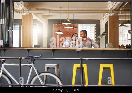 Heureux couple assis dans un café-restaurant pour une journée amusante dans un café ou un restaurant avec paix. Femme et homme à une table se détendre, rire et boire ensemble Banque D'Images