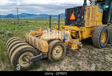 A Walk'n'Roll Packer Roller sur une niveleuse John Deere 772GP garée dans un champ de ferme près d'Almo, Idaho, Etats-Unis Banque D'Images