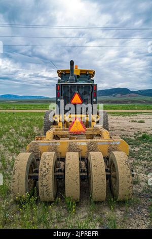 Rouleaux à l'arrière d'une niveleuse John Deere 772GP garés dans un champ de ferme près d'Almo, Idaho, États-Unis Banque D'Images