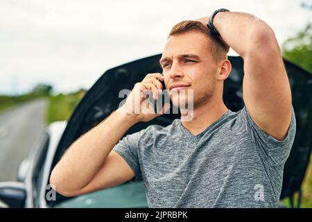 Aide, j'ai obtenu une urgence routière. Un jeune homme qui appelle l'assistance routière après avoir fait panne. Banque D'Images