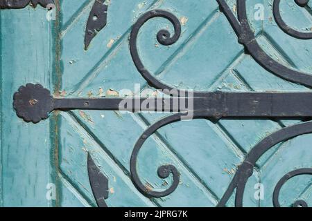 Ancienne ferrure de porte en fer décorée sur une ancienne porte en bois vert, Allemagne Banque D'Images