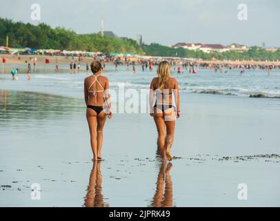 Kuta est une plage qui attire assez bien les visiteurs. Une destination de voyage importante dans le monde pour le surf. Les touristes marchent sur la plage. Banque D'Images