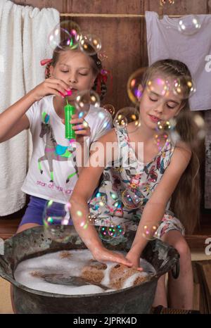 Deux petites amies. Les jolies filles baignent les ours en peluche, soufflent des bulles. Vacances amusantes Banque D'Images