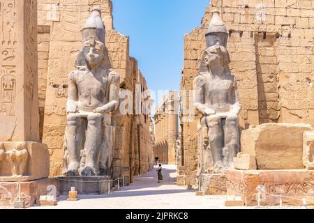 Louxor, Egypte; 17 août 2022 - Un vistor entrant dans l'entrée du Temple de Louxor au milieu de la ville de Louxor, Egypte. Banque D'Images